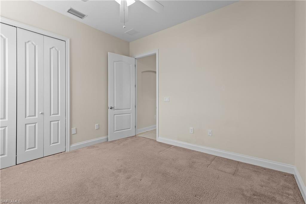 1303 Verde Drive, Unit 1603 Naples, FL 34105 - Photo 11 of 17 Unfurnished bedroom with ceiling fan, a closet, and light colored carpet