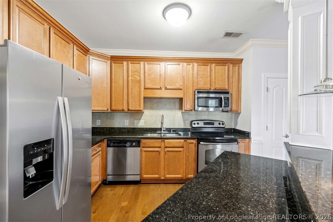 62 Gallery Drive, Unit 102 Spring Lake, NC 28390 - Photo 9 of 23 a kitchen with stainless steel appliances granite countertop a refrigerator a stove and a sink with wooden floor