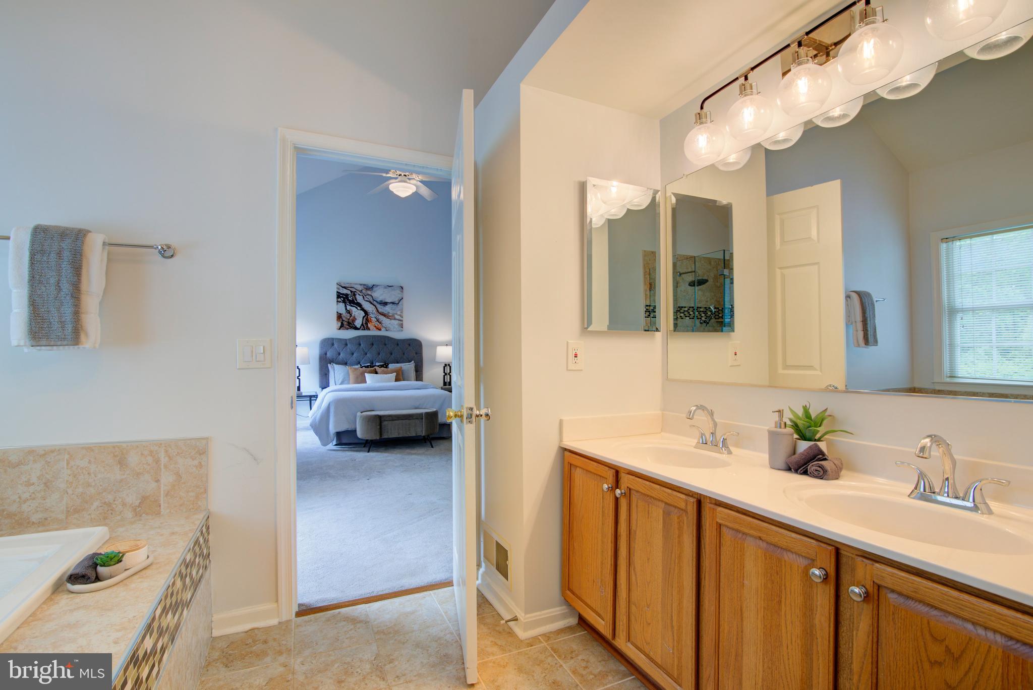 12719 Hitchcock Court Reston, VA 20191 - Photo 26 of 55 a en suite spacious bathroom with a double vanity sink and a mirror