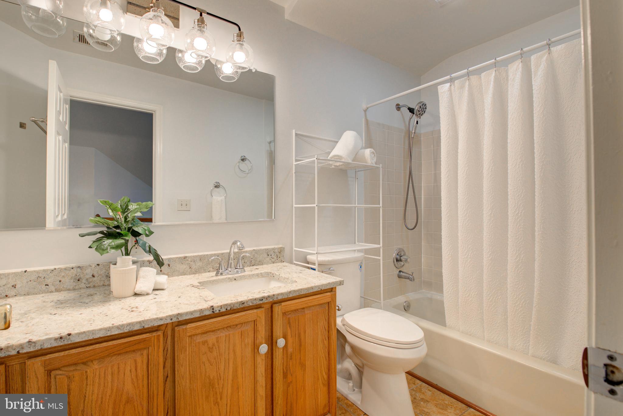12719 Hitchcock Court Reston, VA 20191 - Photo 31 of 55 a bathroom with a granite countertop sink a toilet and a mirror