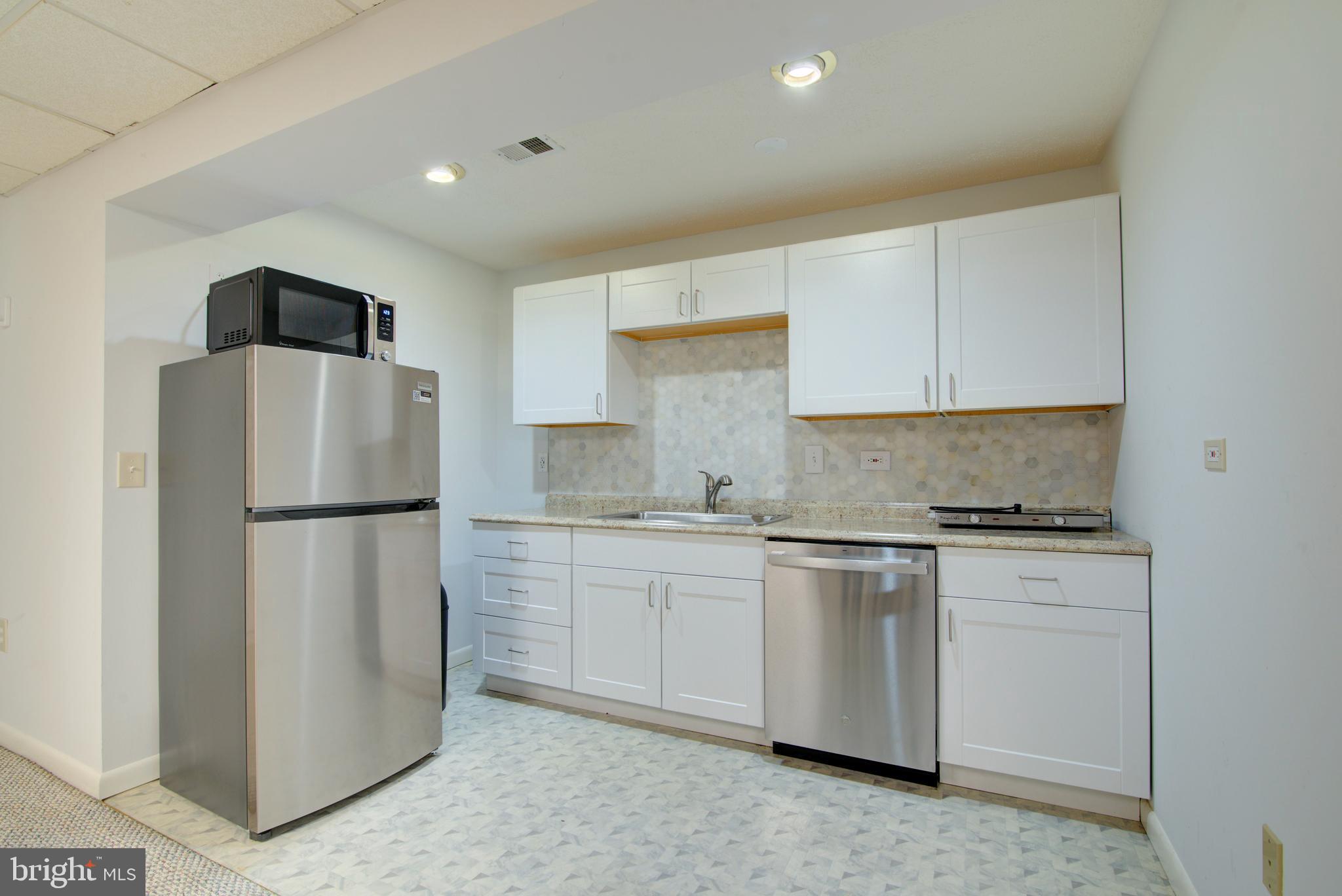 12719 Hitchcock Court Reston, VA 20191 - Photo 41 of 55 a kitchen with stainless steel appliances white cabinets and a refrigerator