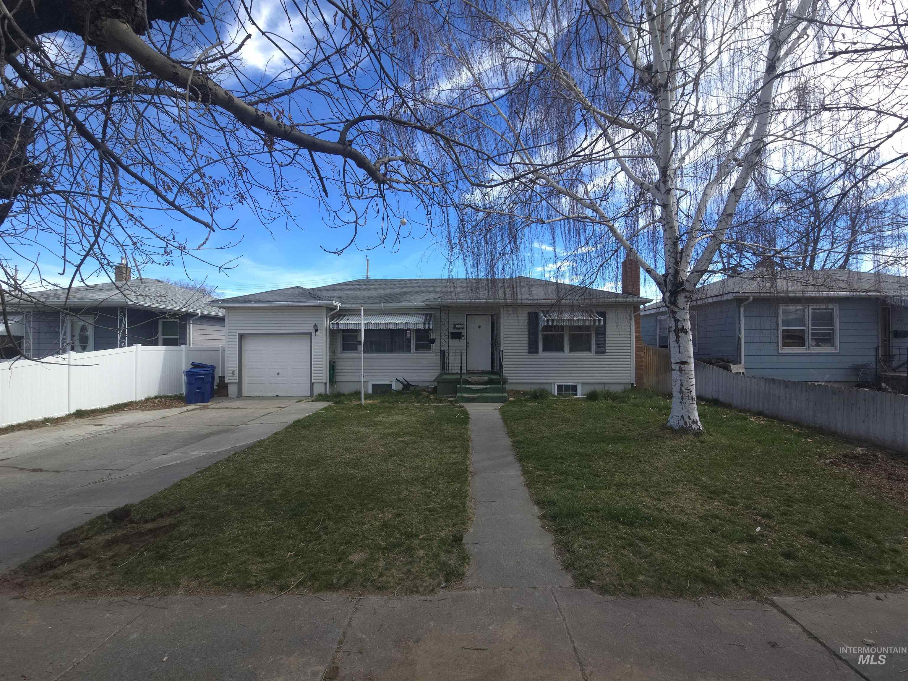 458 Rose Street North Twin Falls, ID 83301 - Photo 1 of 17 Ranch-style house featuring a garage, concrete driveway, and a chimney