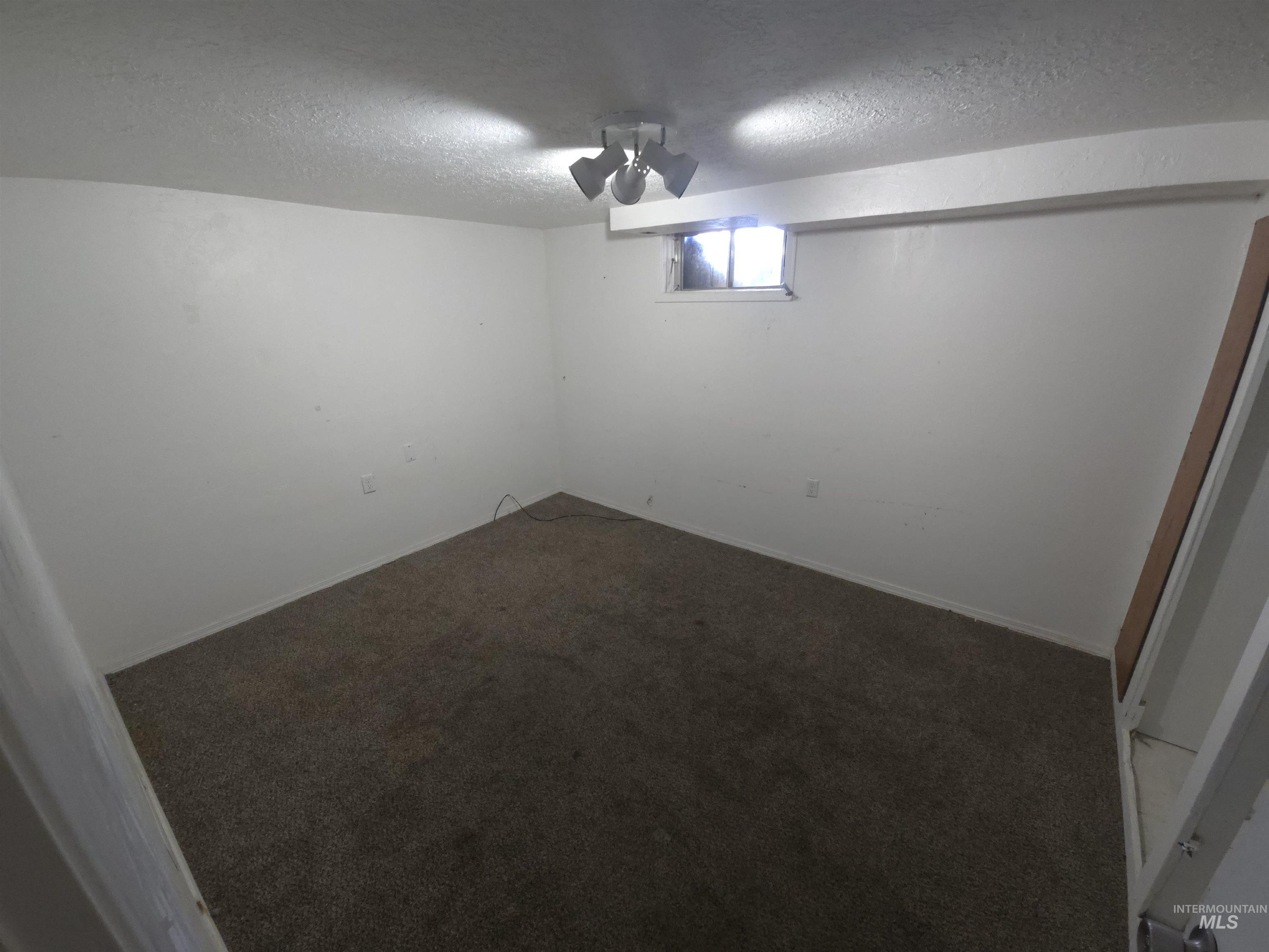 458 Rose Street North Twin Falls, ID 83301 - Photo 11 of 17 Below grade area with dark colored carpet and a textured ceiling