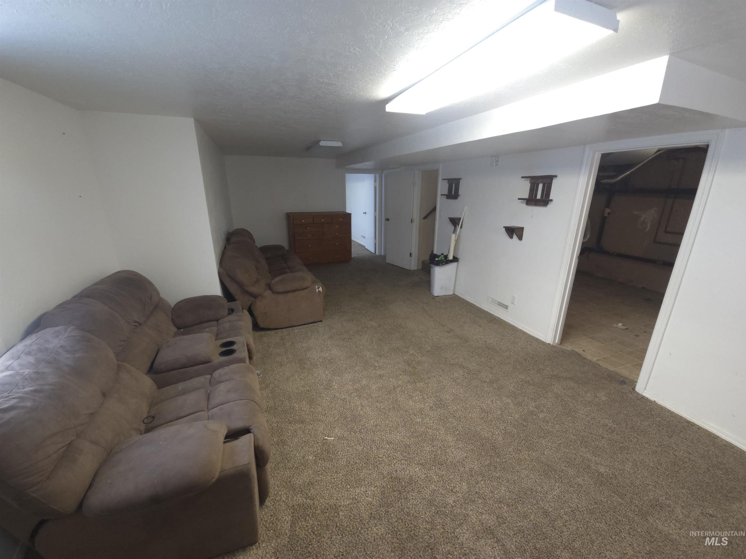 458 Rose Street North Twin Falls, ID 83301 - Photo 13 of 17 Living area featuring carpet floors and a textured ceiling