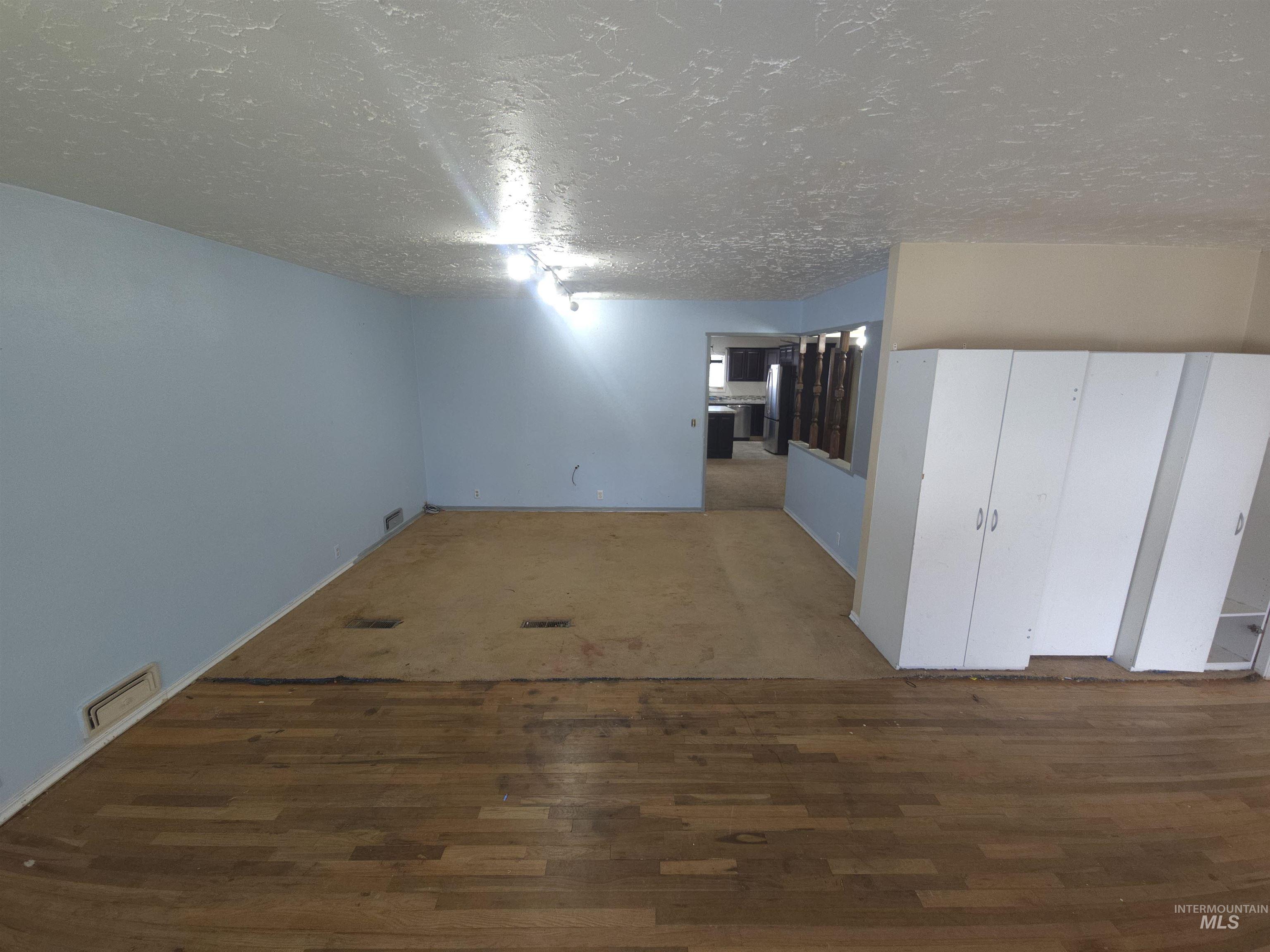 458 Rose Street North Twin Falls, ID 83301 - Photo 4 of 17 Unfurnished room featuring dark wood-style floors and a textured ceiling