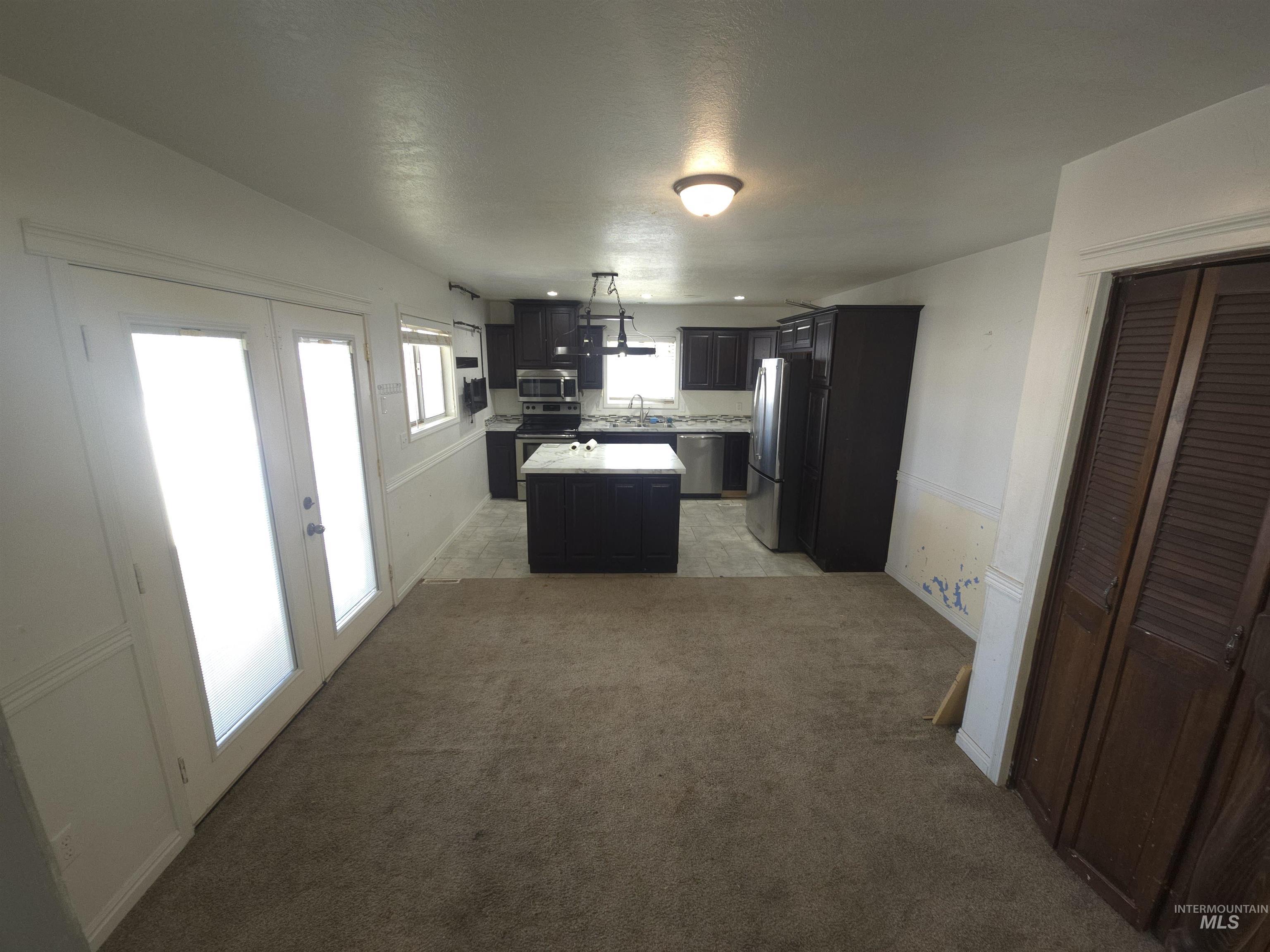 458 Rose Street North Twin Falls, ID 83301 - Photo 8 of 17 Kitchen featuring light countertops, stainless steel appliances, a kitchen island, french doors, and dark cabinets