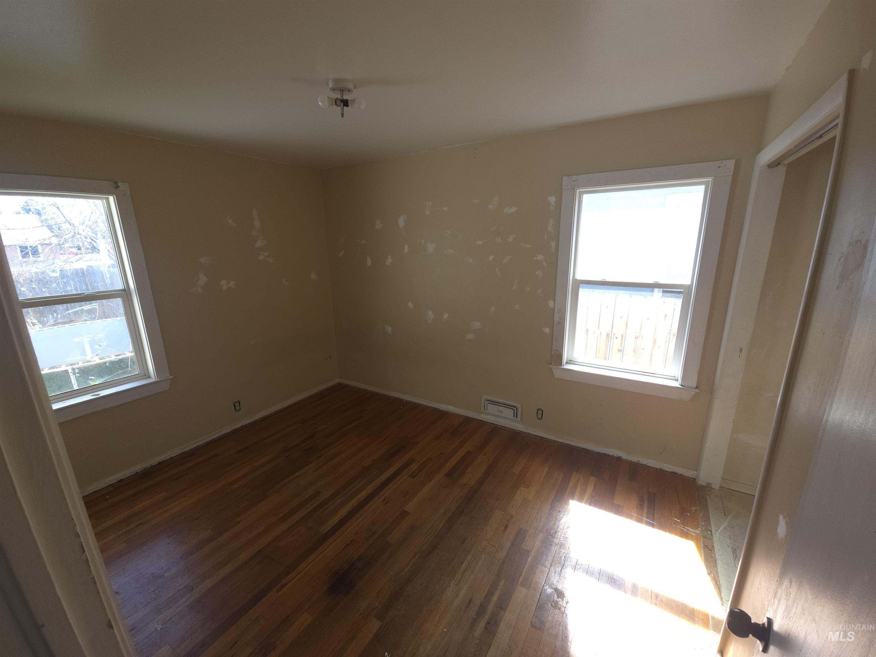 458 Rose Street North Twin Falls, ID 83301 - Photo 9 of 17 Unfurnished bedroom featuring dark wood-style floors and baseboards
