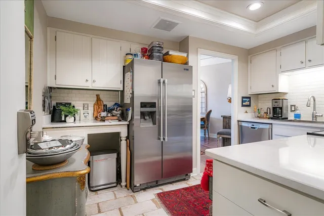 a kitchen with a sink a refrigerator and cabinets