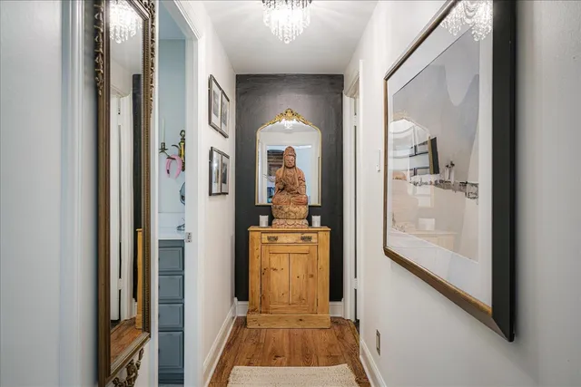 a view of a hallway with wooden floor and a living room