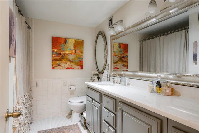 a bathroom with a sink a toilet and a mirror