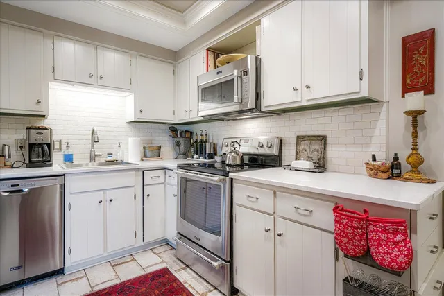 a kitchen with stainless steel appliances granite countertop a sink a stove and cabinets