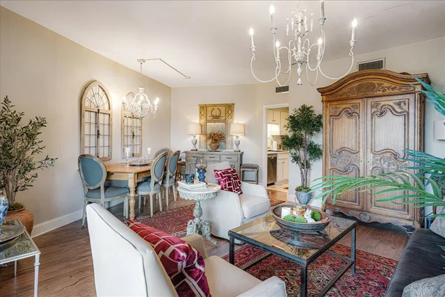 a living room with furniture a chandelier and a large mirror