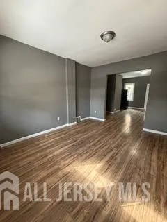 a view of empty room with window and wooden floor