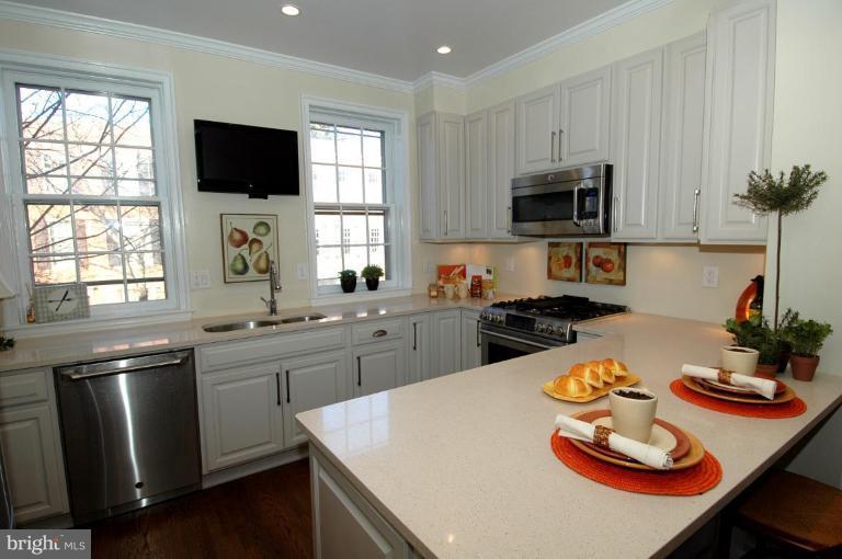 3318 R Street Northwest Washington, DC 20007 - Photo 7 of 26 a kitchen with stainless steel appliances wooden floor dining table and chairs