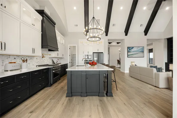 a dining room with stainless steel appliances granite countertop a dining table chairs and chandelier