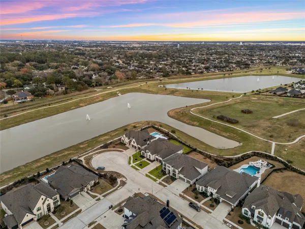 an aerial view of a house with a swimming pool yard and lake view