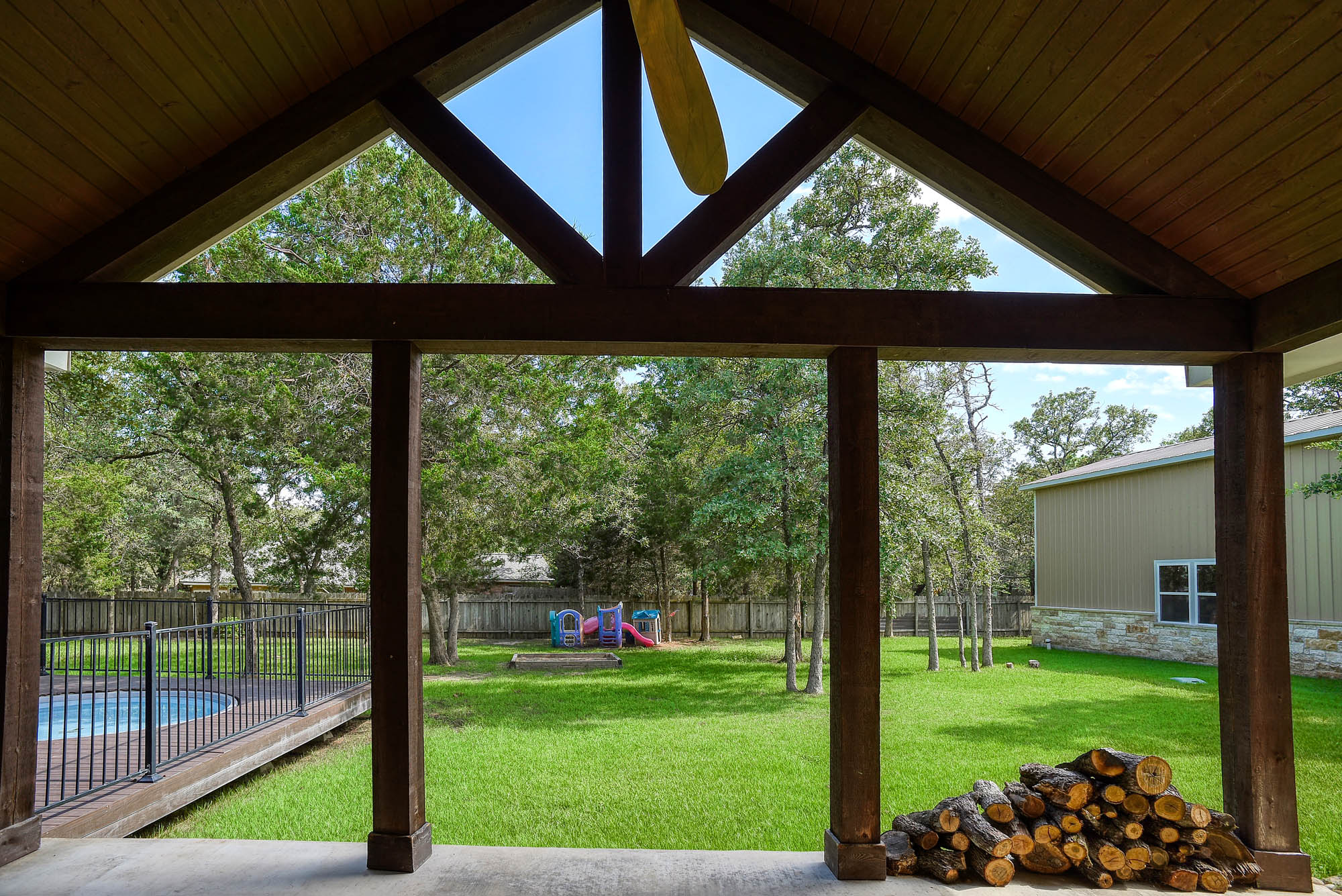 115 Pine Point Cove Elgin, TX 78621 - Photo 31 of 39 A spacious backyard vista from a covered patio, featuring a sparkling pool, verdant lawn, and mature trees.