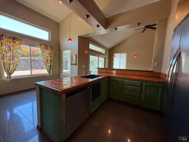 a kitchen with stainless steel appliances granite countertop a sink and a large window