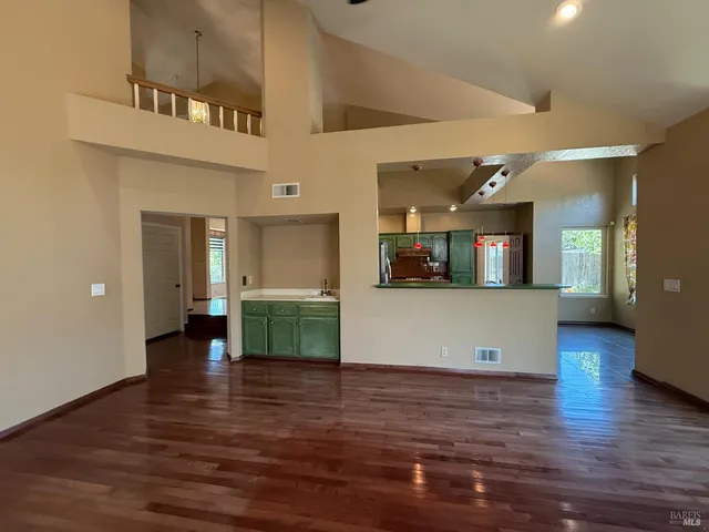 a view of a living room with kitchen and furniture