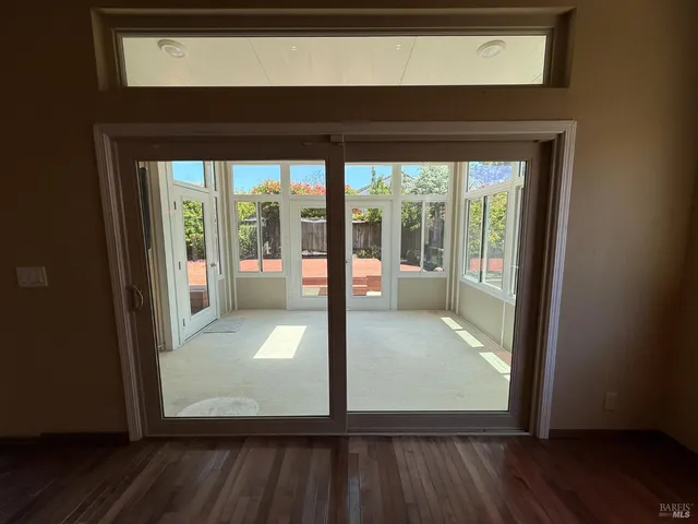 a view of a hallway with wooden floor and dining room