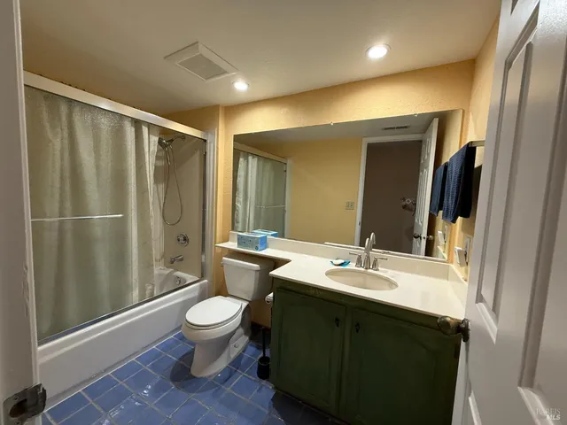 a bathroom with a double vanity sink toilet and shower
