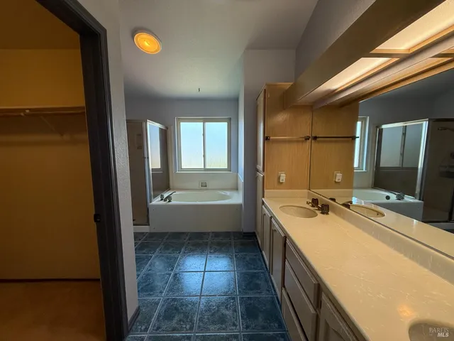 a bathroom with a tub sink and mirror