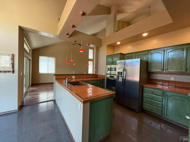 a kitchen with stainless steel appliances granite countertop a refrigerator a sink and a stove