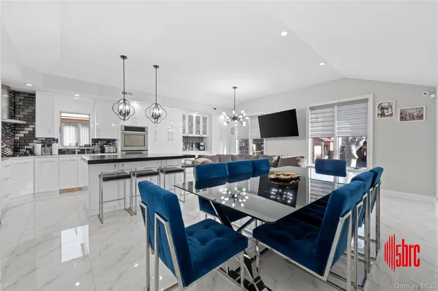 a kitchen with stainless steel appliances a dining table and chairs