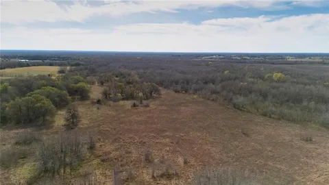 a view of a dry yard with wooden fence
