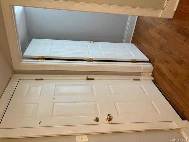 101 Maple Avenue Sea Cliff, NY 11579 - Photo 4 of 9 an empty room with wooden floor and entrance