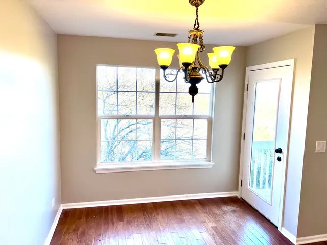 a view of a room with wooden floor and windows
