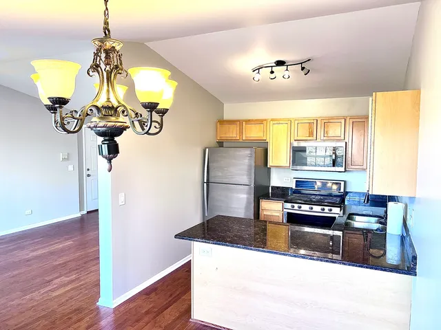 a kitchen with stainless steel appliances granite countertop a sink refrigerator and window