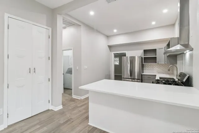 a view of a big room with wooden floor and windows