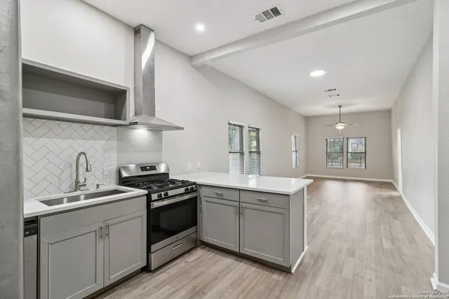 a view of large kitchen with stainless steel appliances refrigerator oven and cabinets