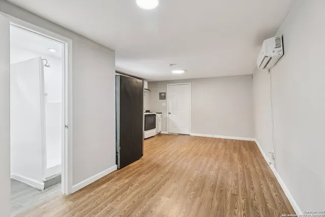 an empty room with wooden floor and window