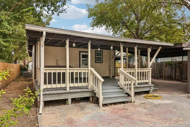 a backyard of a house with plants and wooden fence