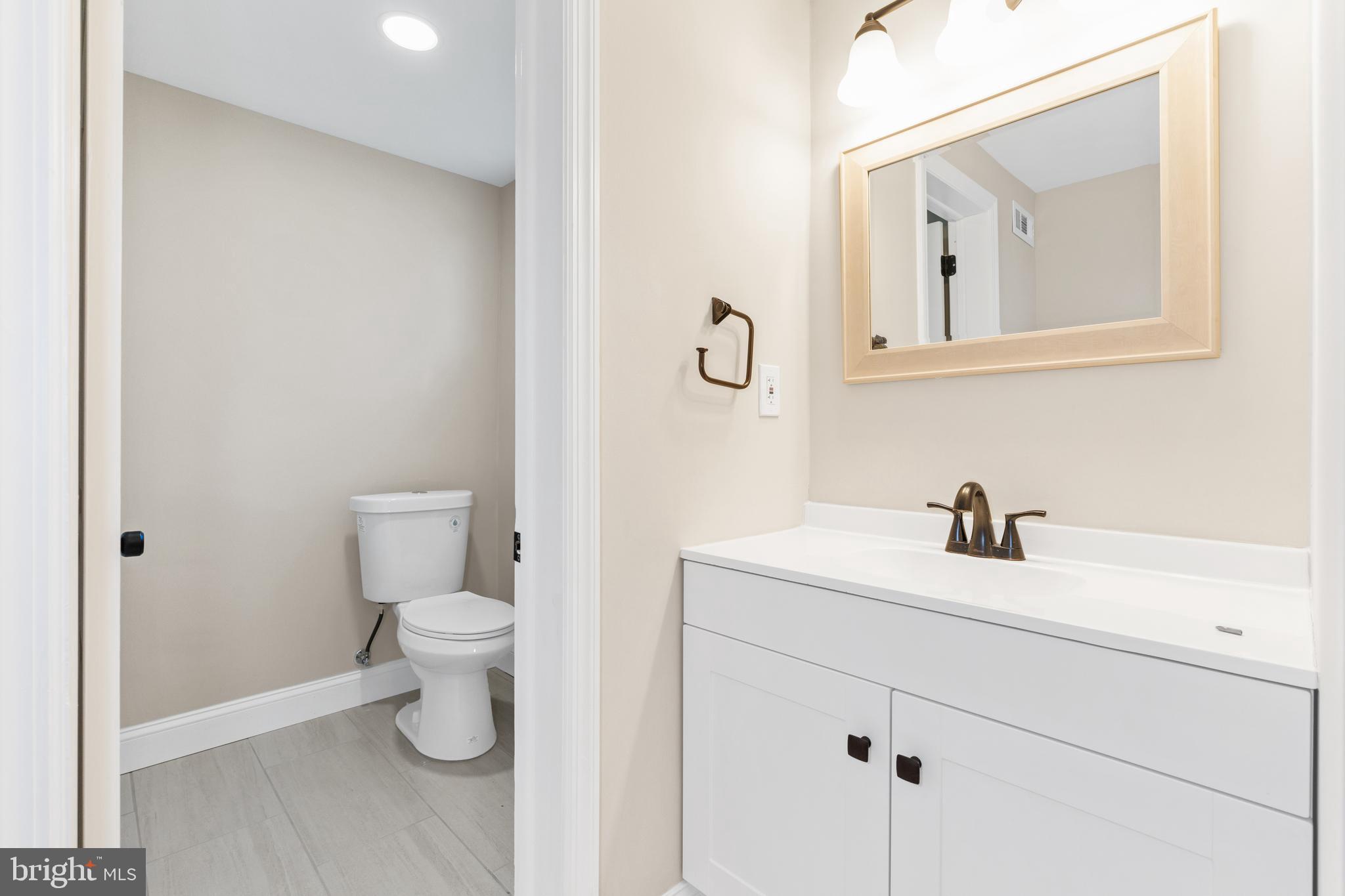 628 South Brownleaf Road Newark, DE 19713 - Photo 26 of 36 a bathroom with a toilet sink vanity and mirror