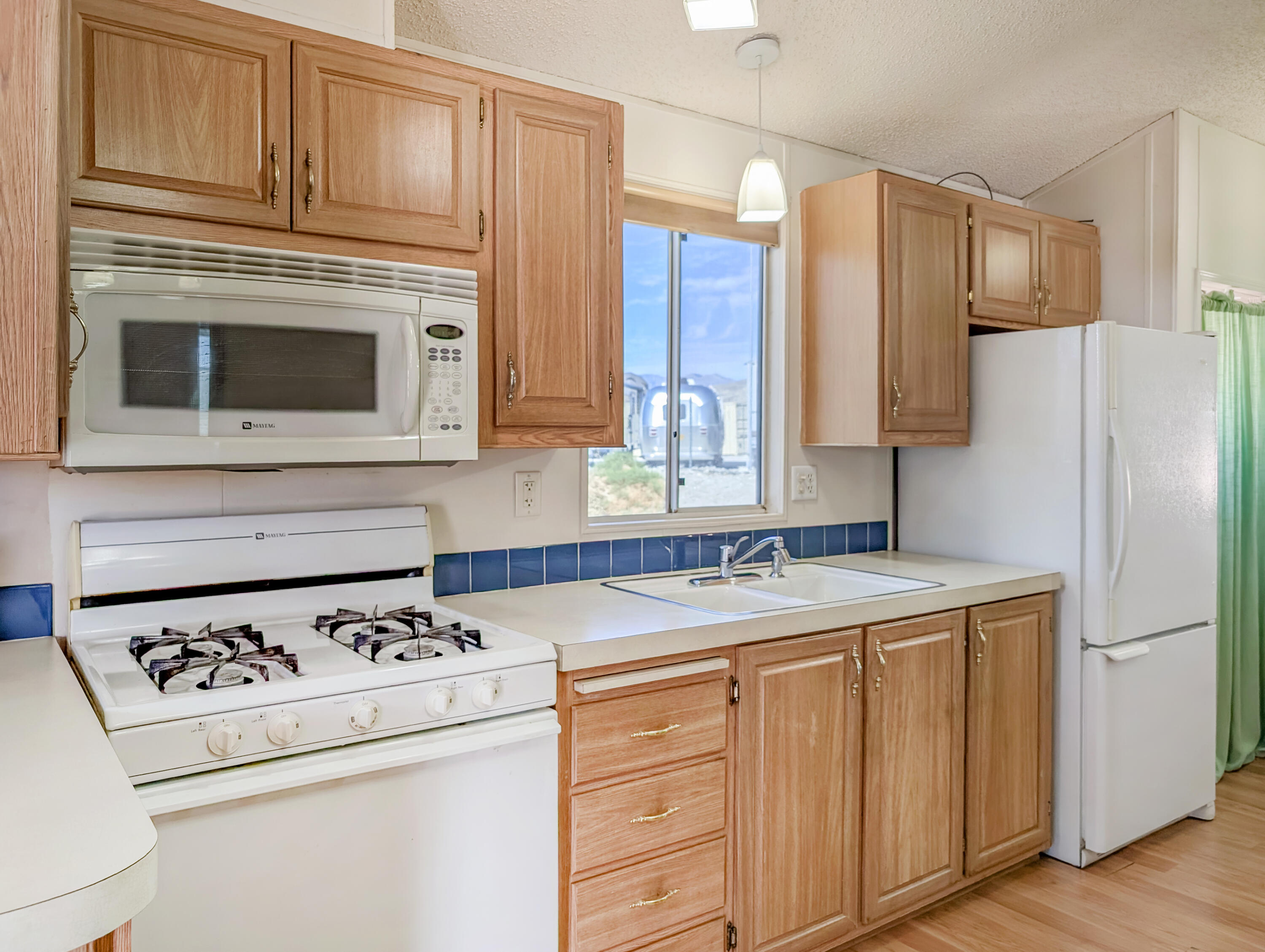 70200 Dillon Road, Unit 422 Desert Hot Springs, CA 92241 - Photo 15 of 25 a kitchen with a stove a refrigerator and cabinets