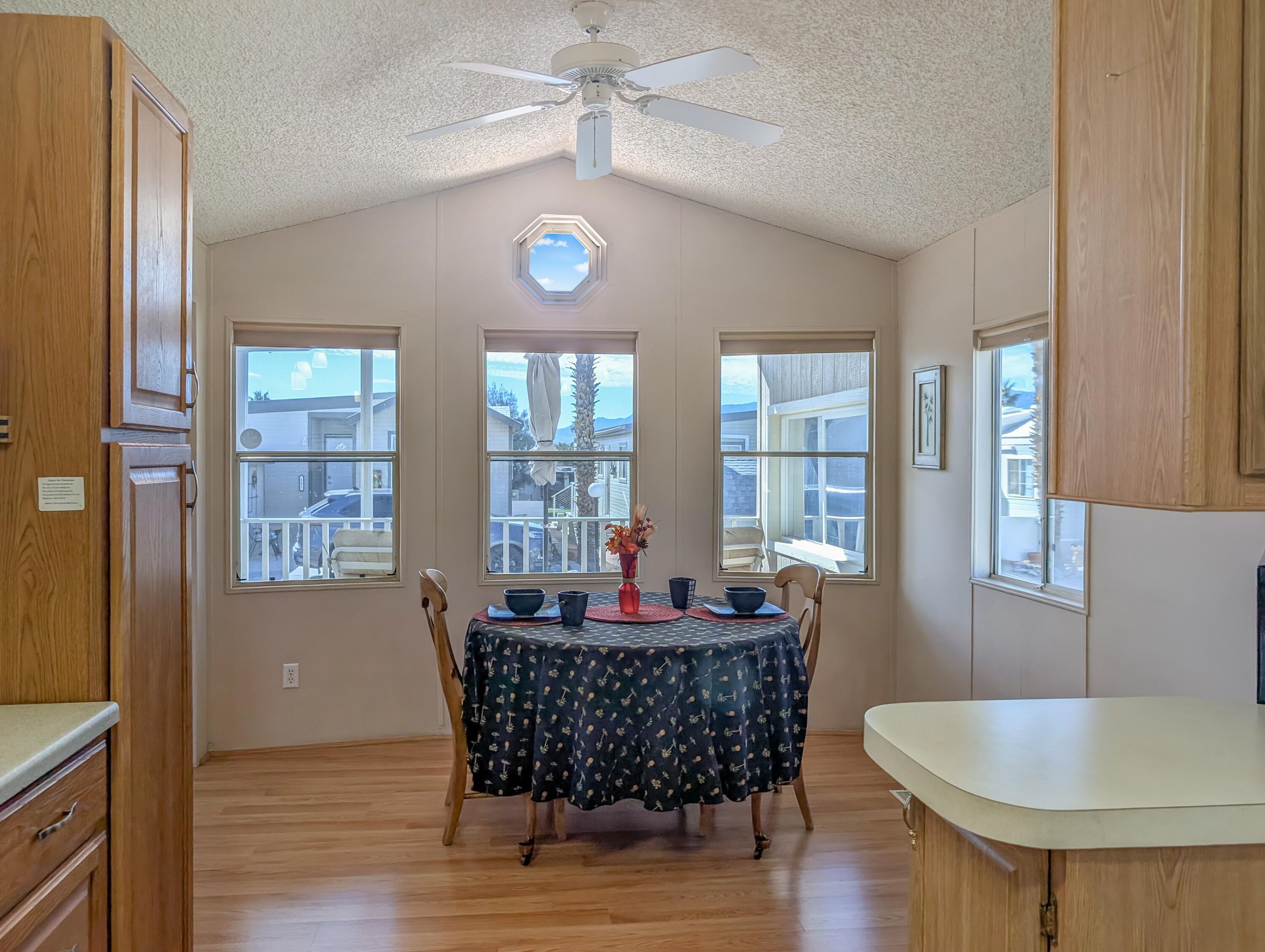 70200 Dillon Road, Unit 422 Desert Hot Springs, CA 92241 - Photo 17 of 25 a dining room with furniture a chandelier and wooden floor