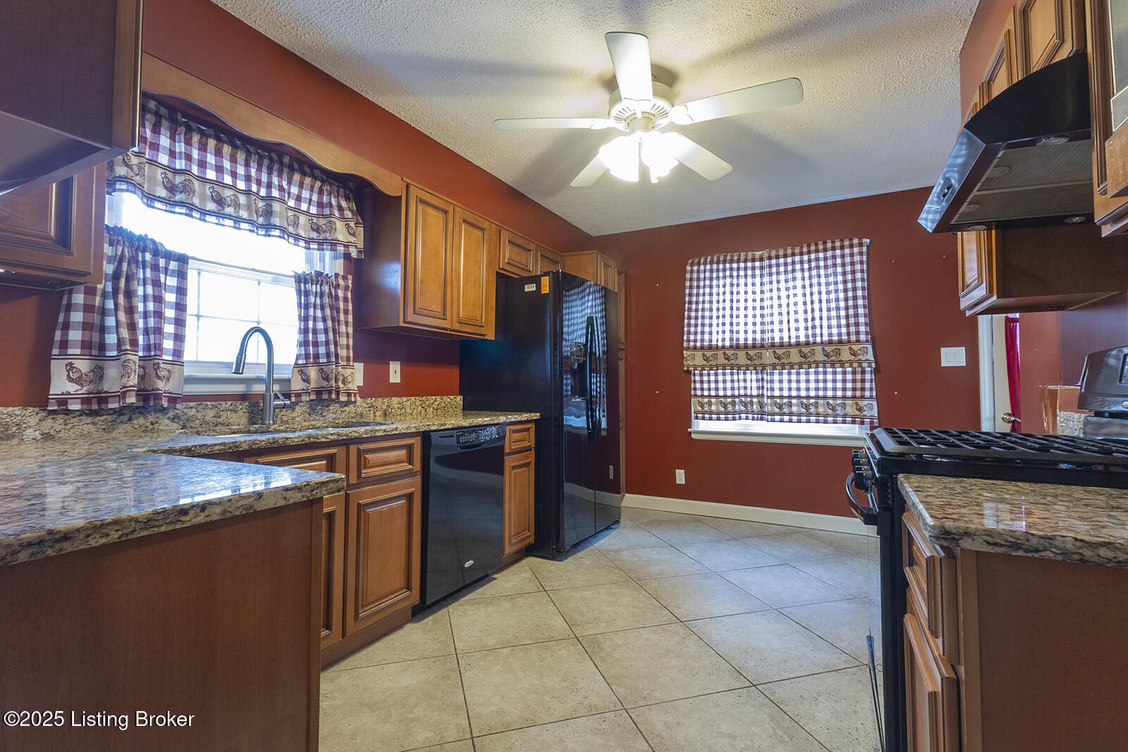Spacious kitchen with granite counters, custom wood cabinets and gas stove