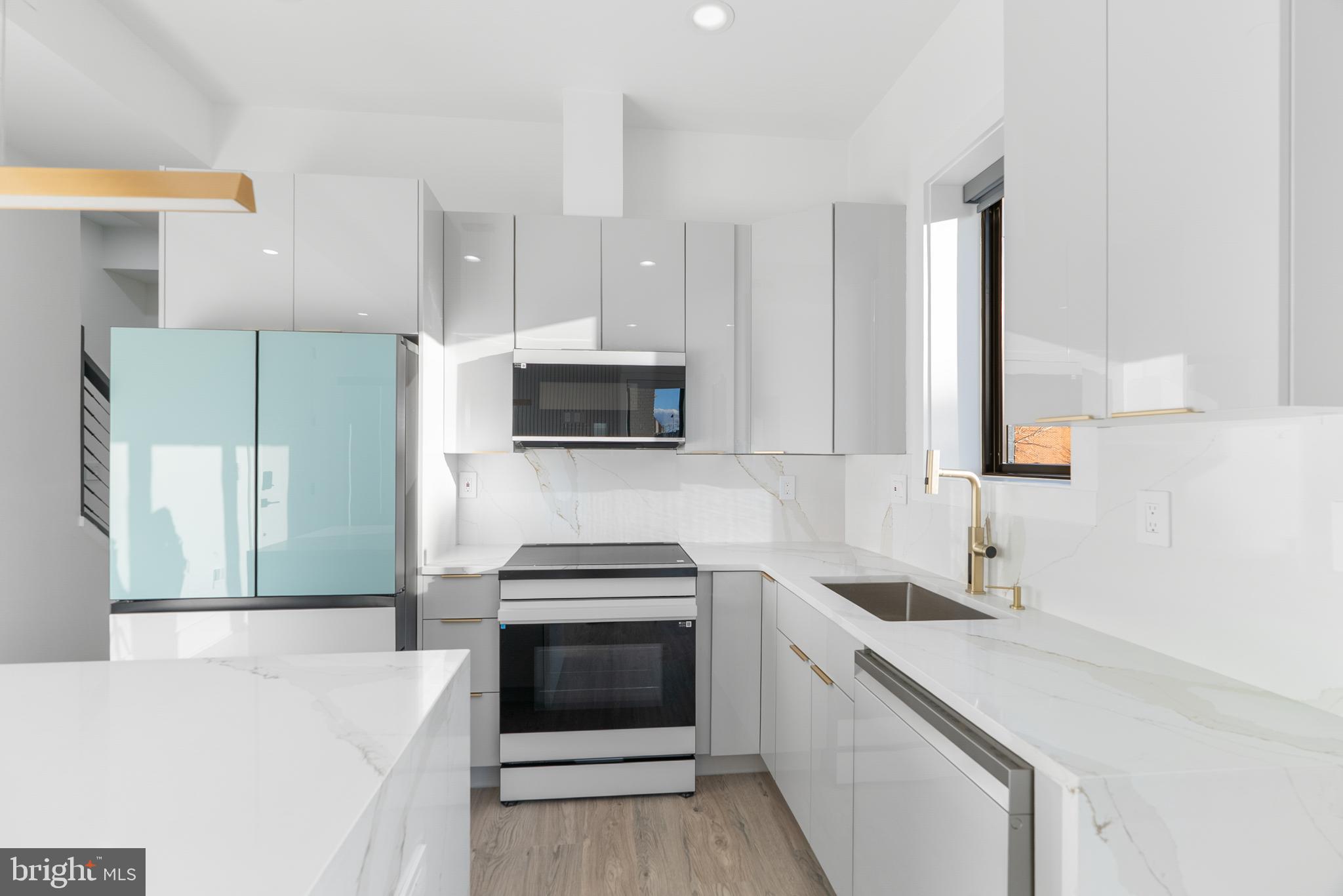 1140 Oates Street Northeast, Unit 202 Washington, DC 20002 - Photo 20 of 48 a kitchen with stainless steel appliances a stove microwave and sink