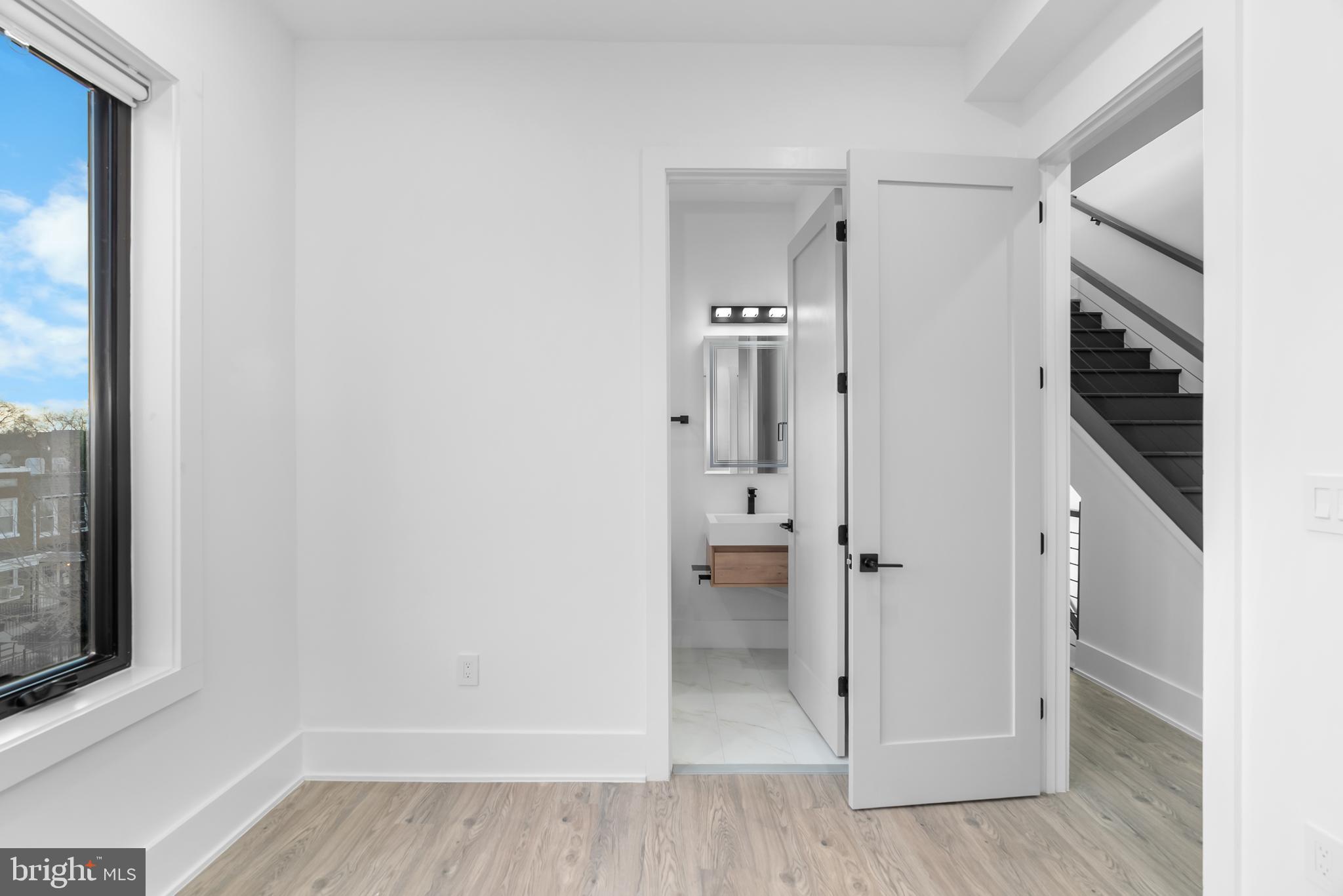 1140 Oates Street Northeast, Unit 202 Washington, DC 20002 - Photo 30 of 48 a view of a livingroom with wooden floor and a bathroom
