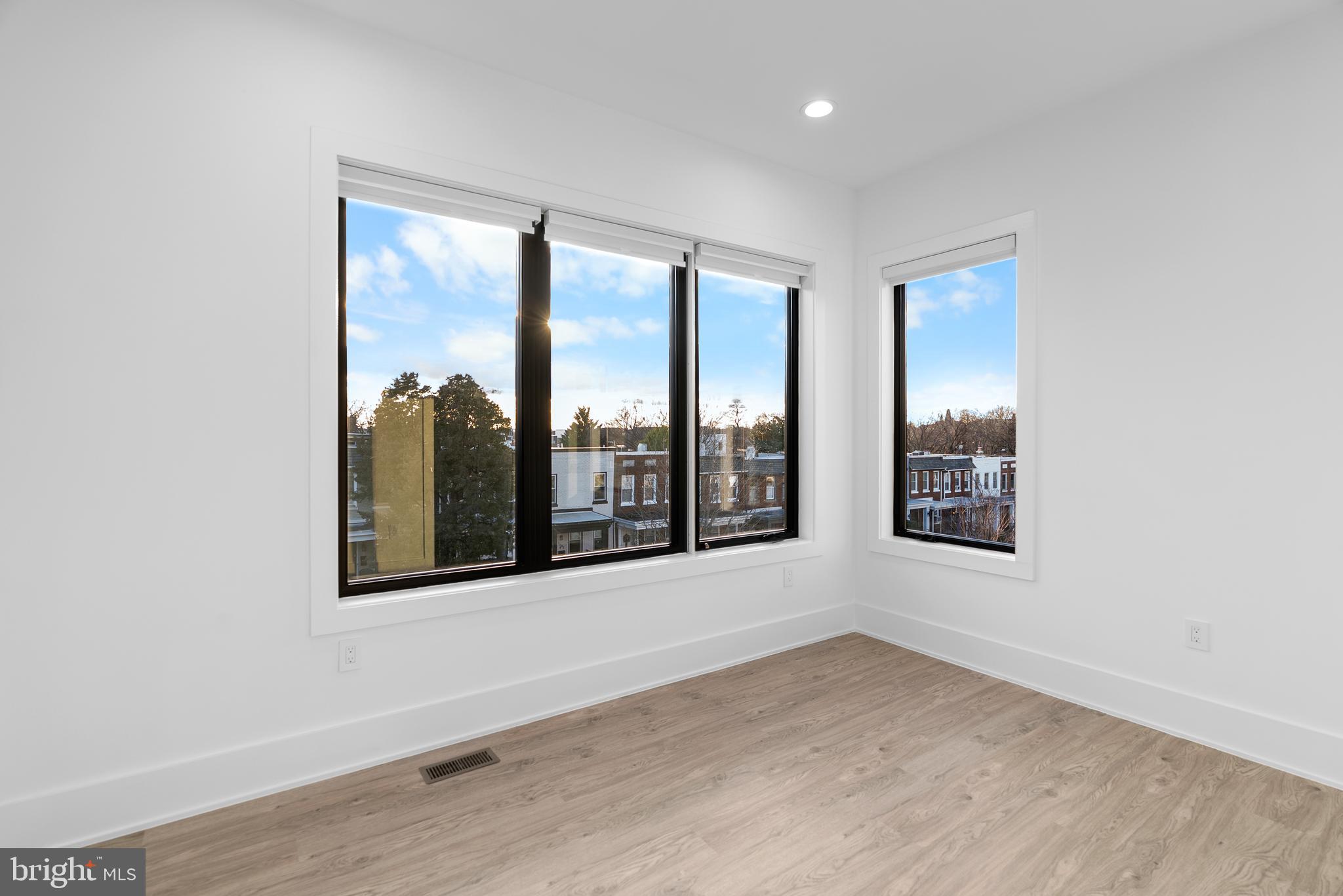 1140 Oates Street Northeast, Unit 202 Washington, DC 20002 - Photo 32 of 48 an empty room with wooden floor and windows