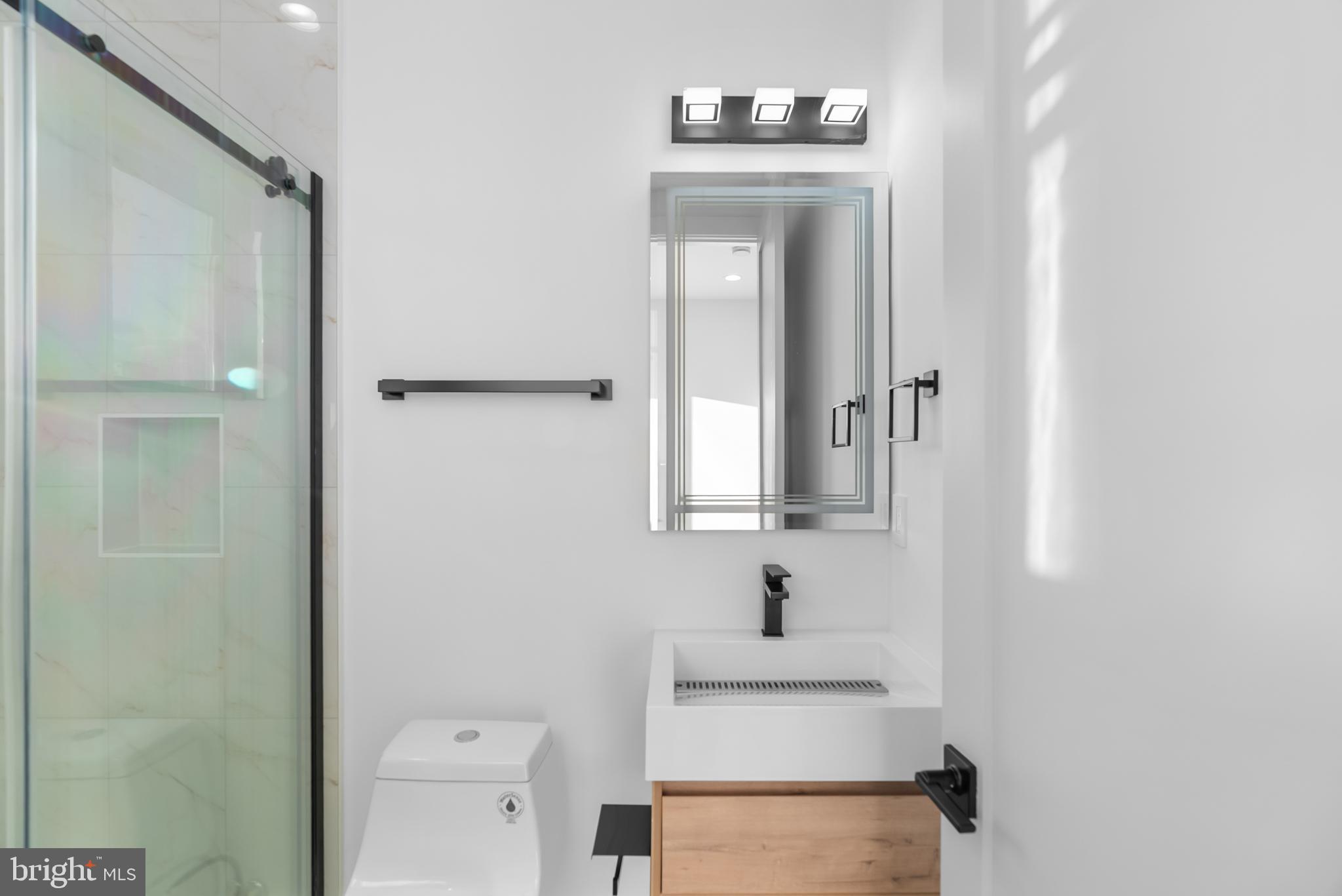 1140 Oates Street Northeast, Unit 202 Washington, DC 20002 - Photo 40 of 48 a bathroom with a sink a toilet and mirror
