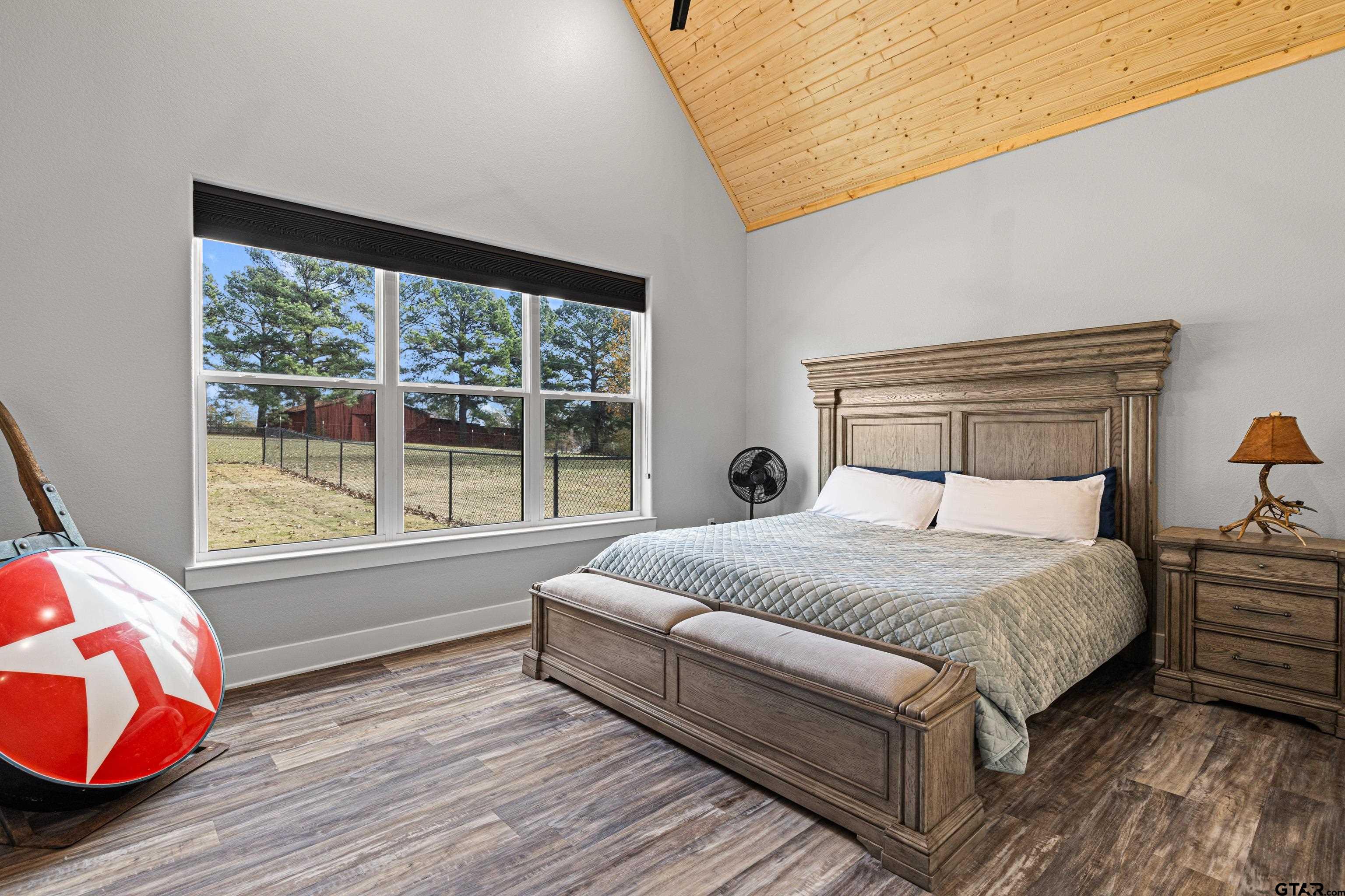 8947 Pomagranate Road Gilmer, TX 75645 - Photo 22 of 38 a bedroom with a bed and wooden floor