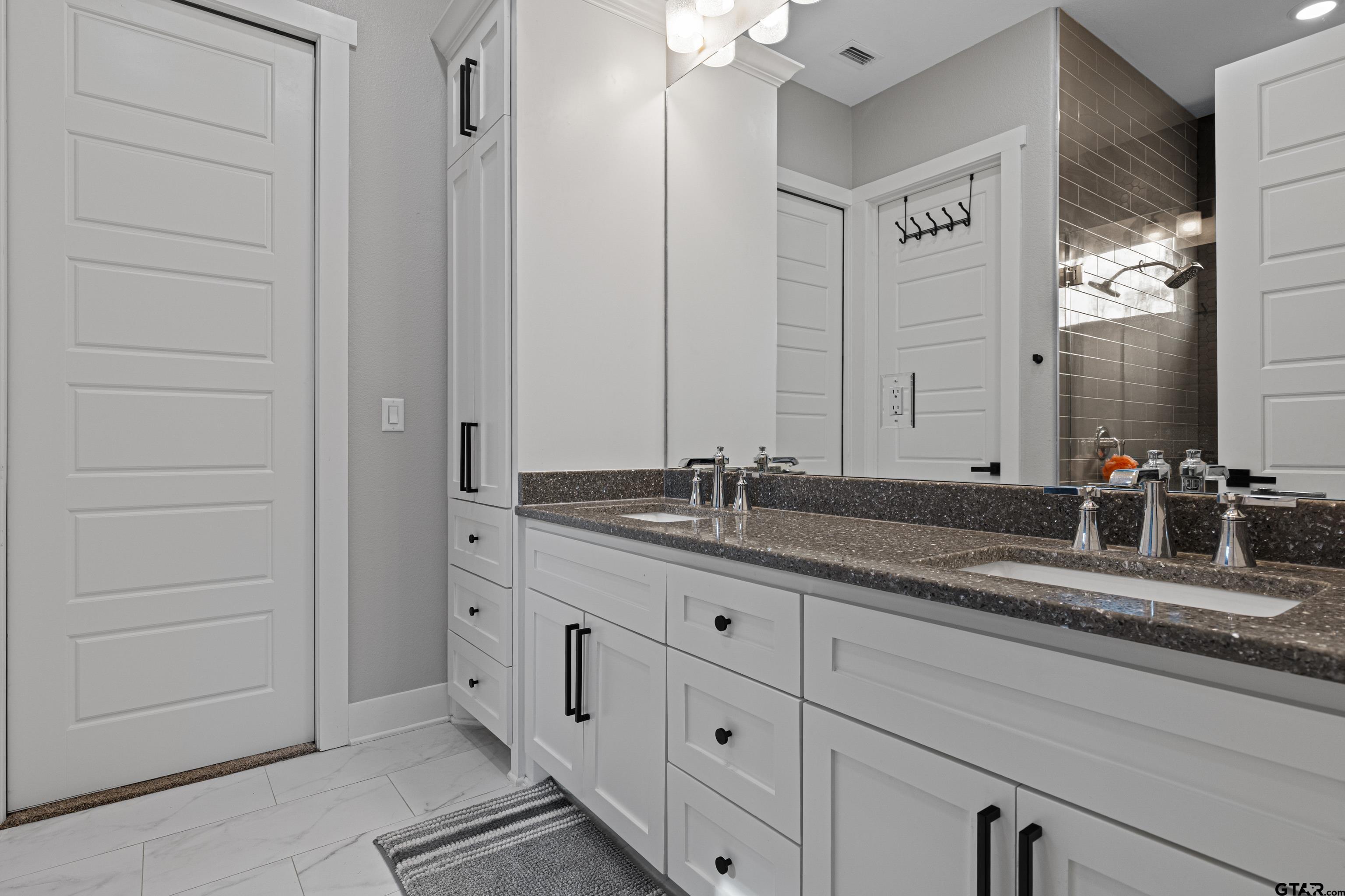 8947 Pomagranate Road Gilmer, TX 75645 - Photo 24 of 38 a bathroom with a double vanity sink and a mirror