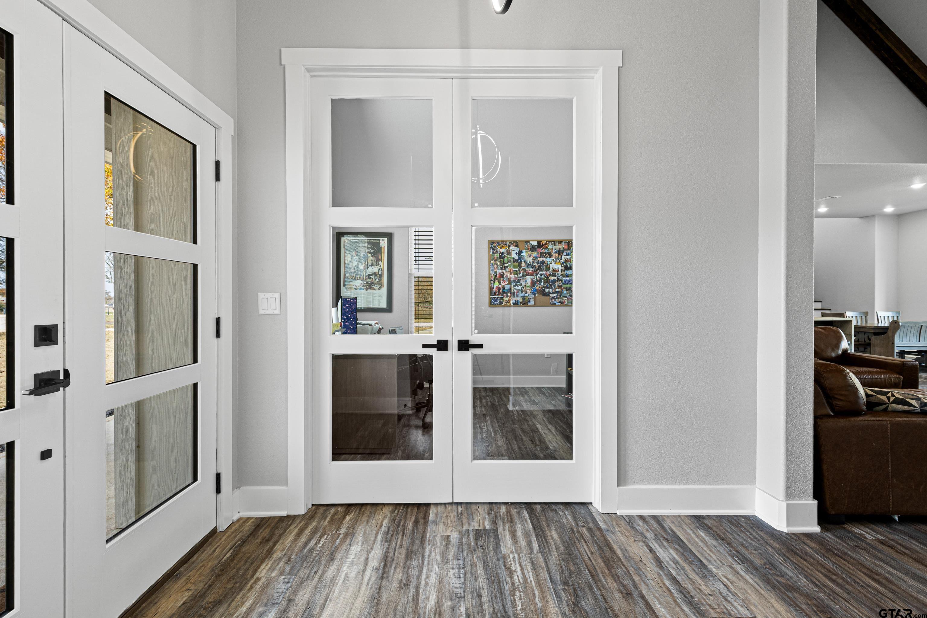 8947 Pomagranate Road Gilmer, TX 75645 - Photo 31 of 38 a view of a hallway with wooden floor and a living room