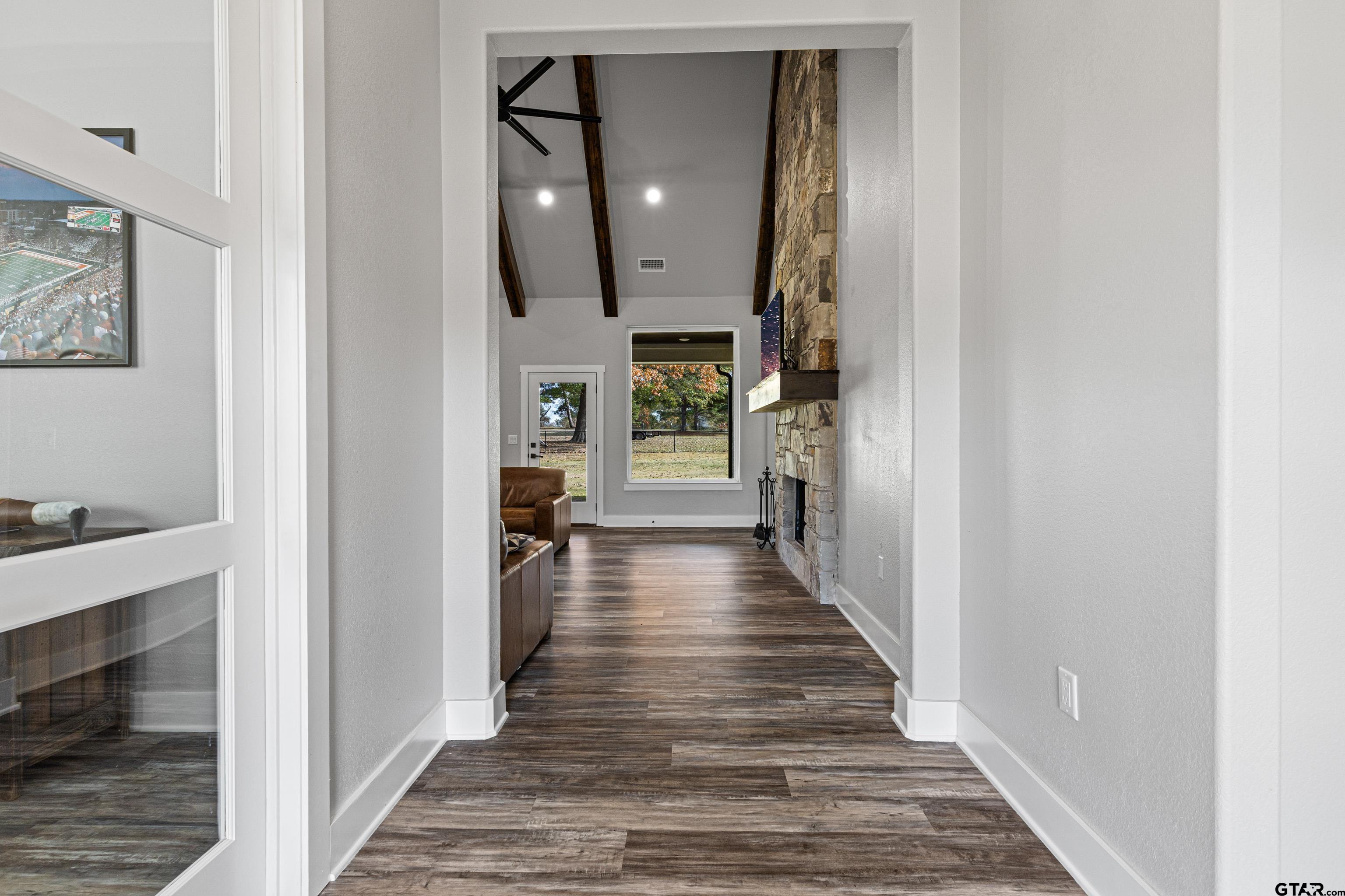 8947 Pomagranate Road Gilmer, TX 75645 - Photo 6 of 38 a view of a hallway with wooden floor and staircase