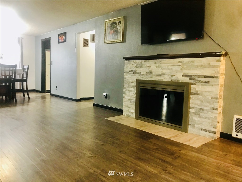 8410 Custer Road Southwest Lakewood, WA 98499 - Photo 7 of 16 a view of an empty room with wooden floor and a fireplace