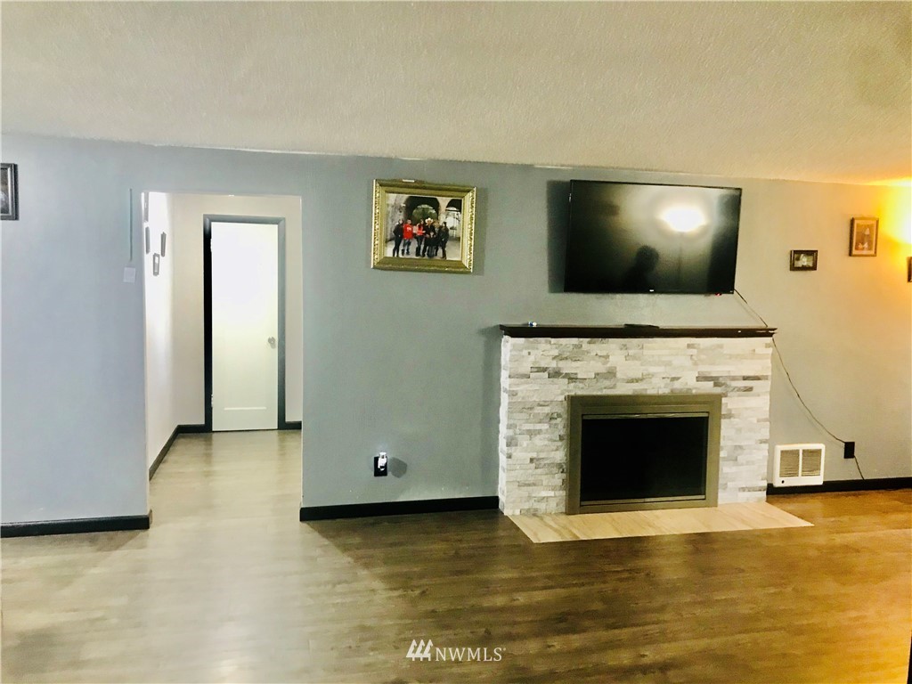8410 Custer Road Southwest Lakewood, WA 98499 - Photo 8 of 16 a view of empty room with wooden floor and fireplace